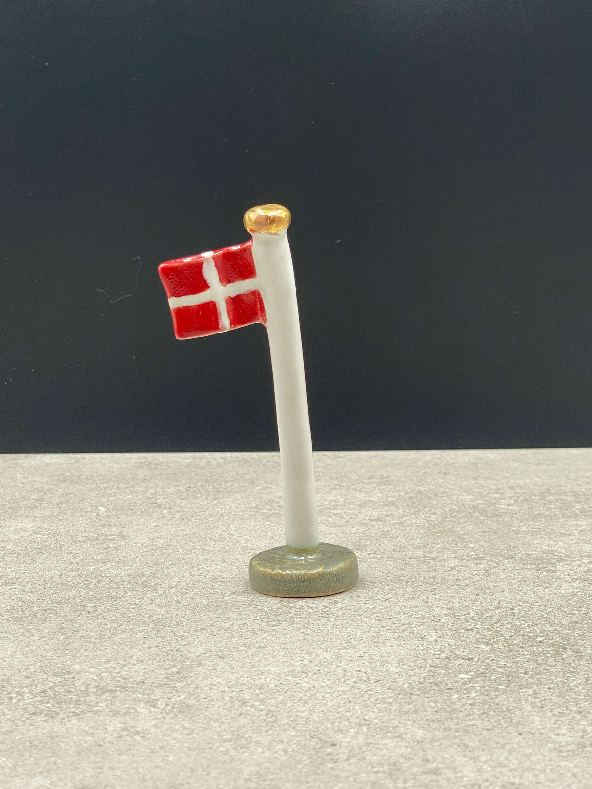 Keramikflag med Dannebrog og guldknop i toppen