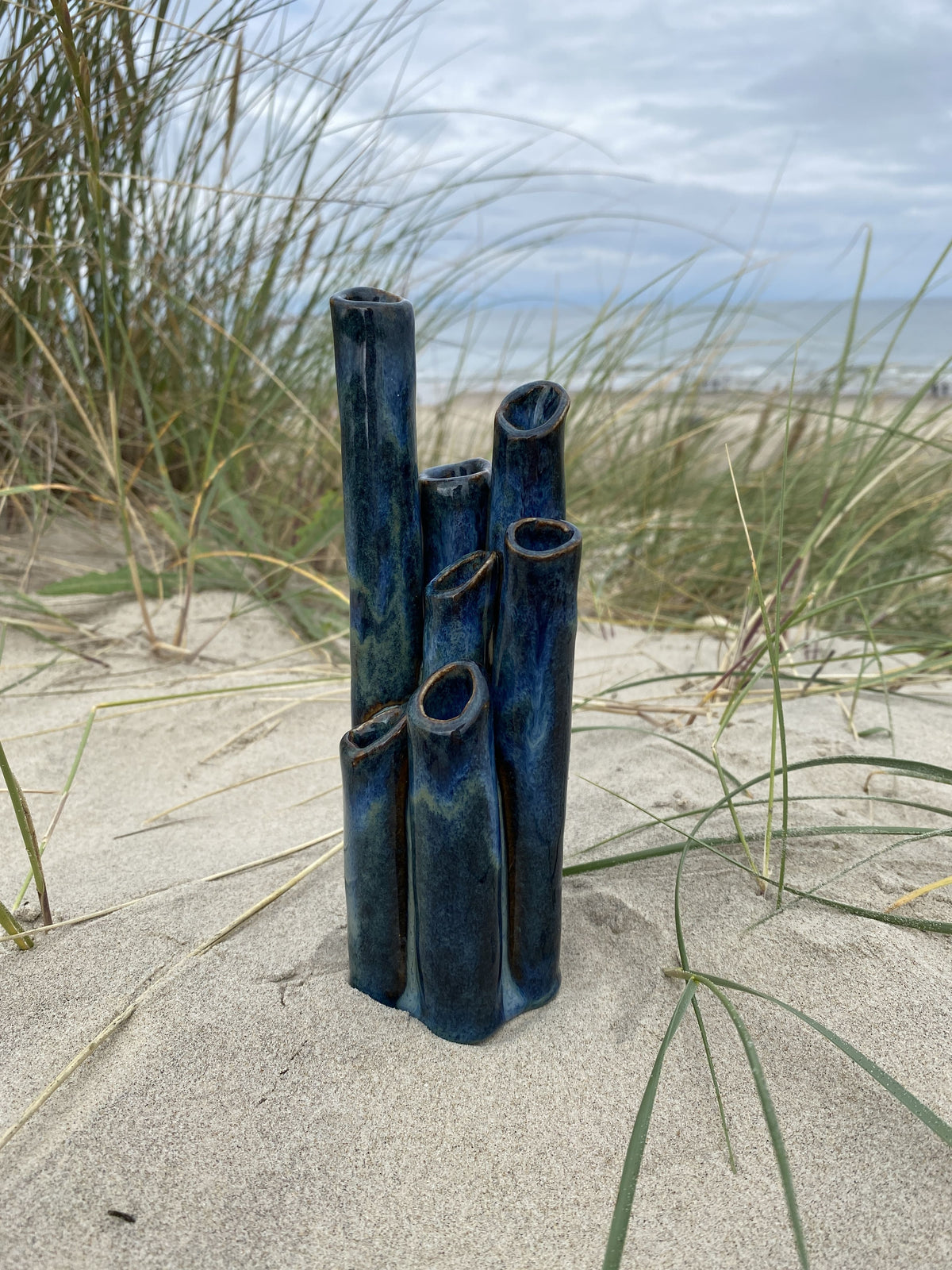Vase Blue Sea formet som rør i dyb blå glasur, i klitterne – håndlavet keramik fra Keramikbyh