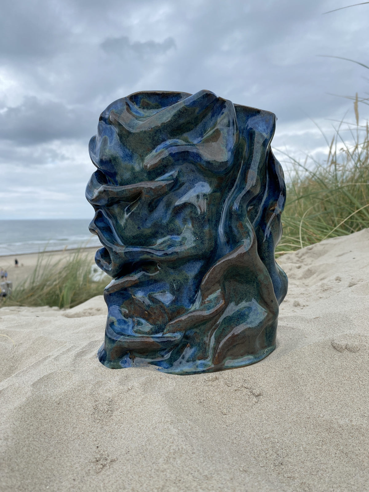 Foldet vase Blue Folded i blå glasur med organiske folder, i klitterne – håndlavet keramik fra Keramikbyh