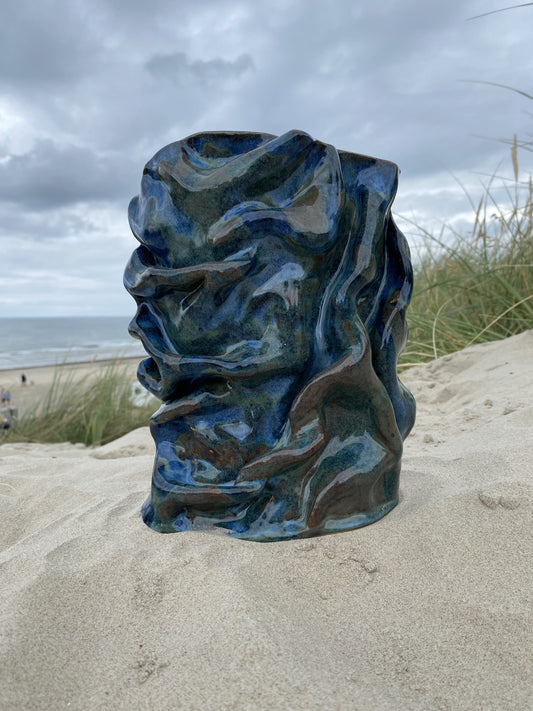 Foldet vase Blue Folded i blå glasur med organiske folder, i klitterne – håndlavet keramik fra Keramikbyh