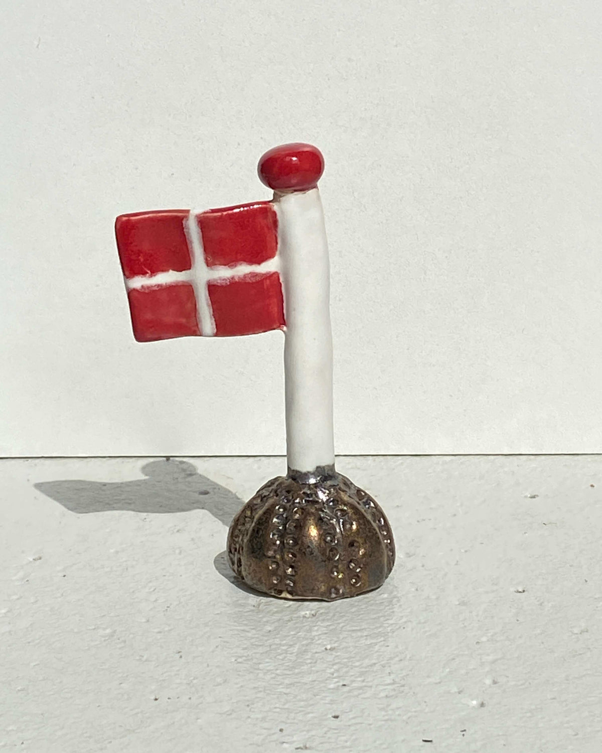 Keramikflag Kobber med Dannebrog på brun fod formet som søpindsvin – håndlavet keramik fra Keramikbyh