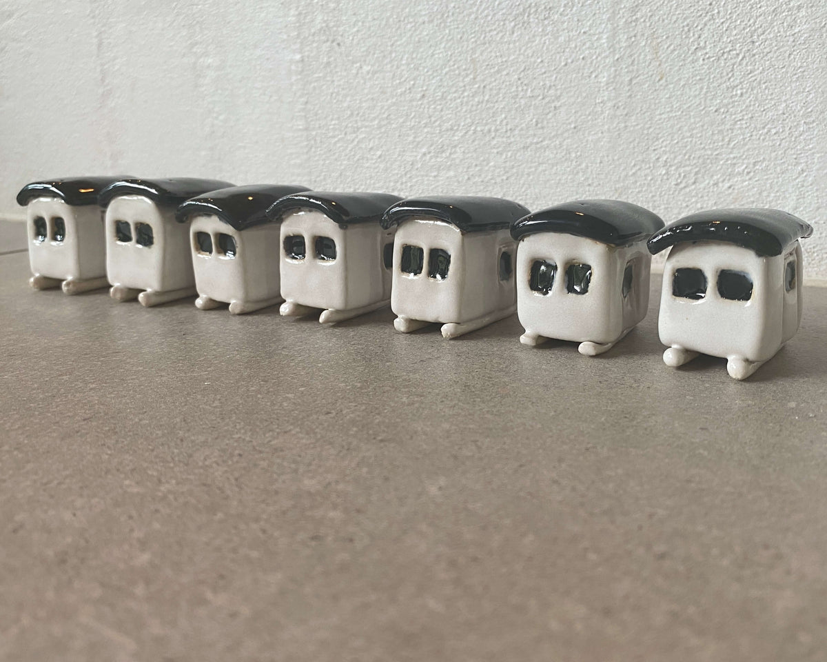 Række af hvide strandhuse i keramik